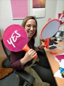 Lucy Weil, marketing and branding creating paddles for the Yes or No Game on Hope 103.2's Facebook