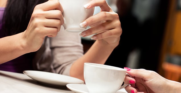 Two girlfriends talking over coffee 