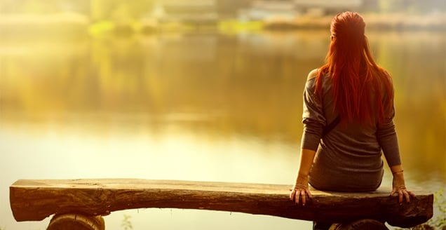 Woman sitting by a lake