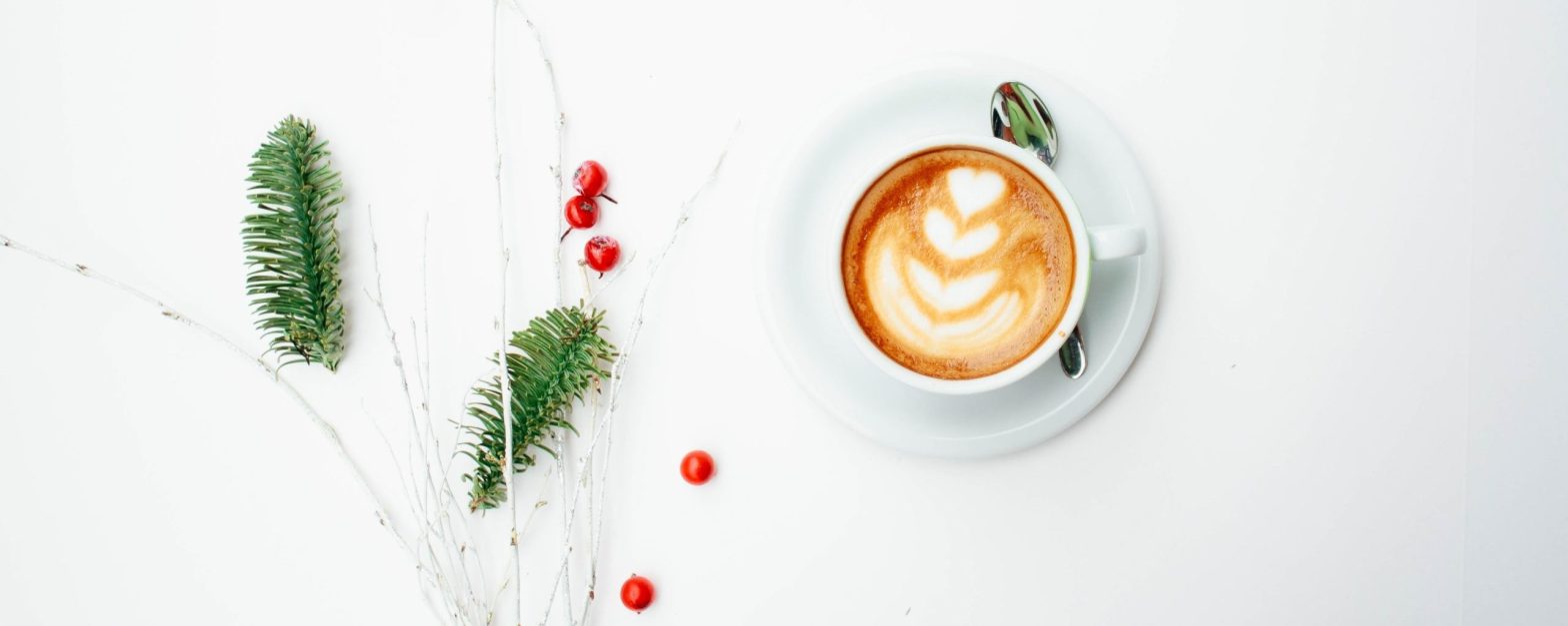 Coffee and Christmas foliage, Photo by Toa Heftiba on Unsplash