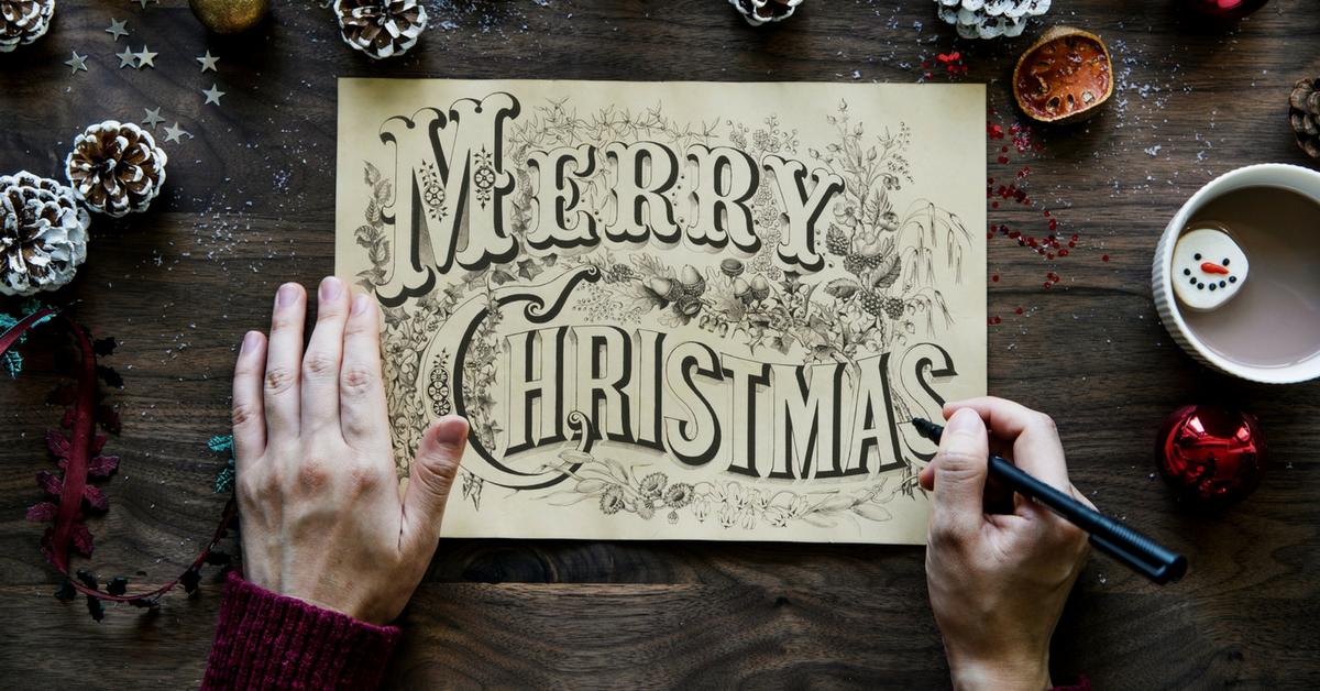 Merry Christmas sign on desk, hand with texta
