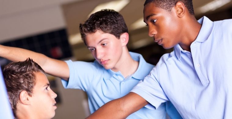 Boys bullying another boy at high school