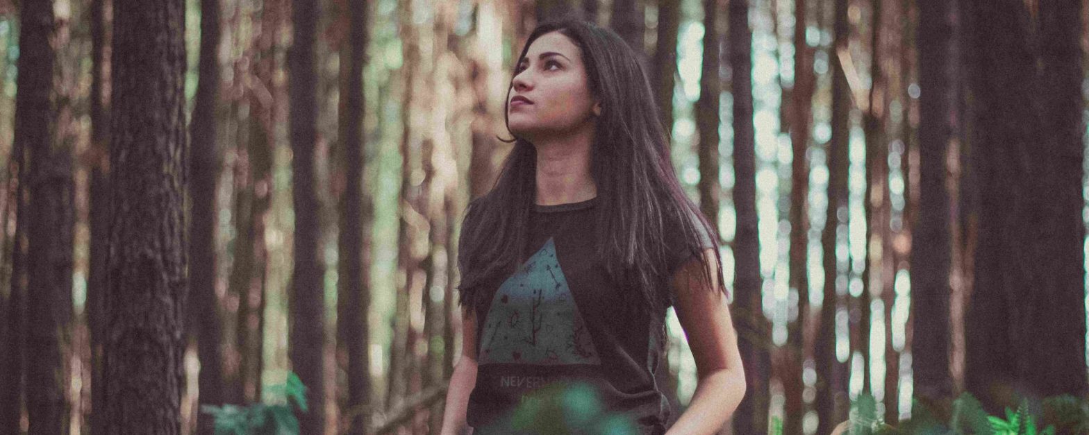 Woman in forest looking up -