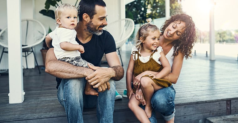 Couple and two kids sitting on verandah