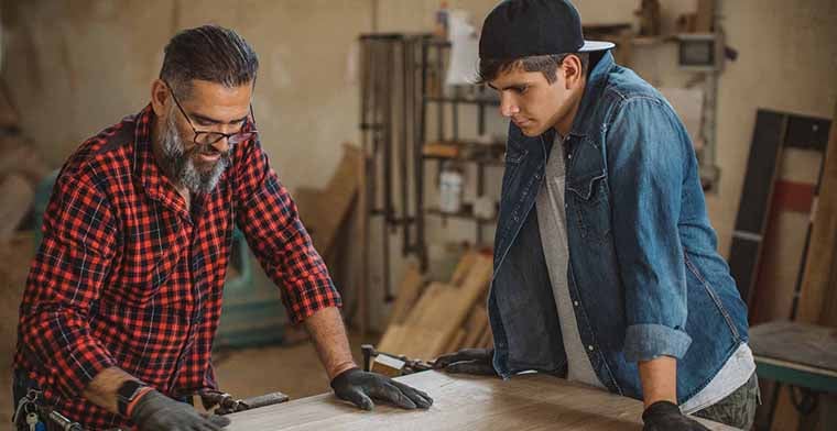 Dad and son in carpenter workshop