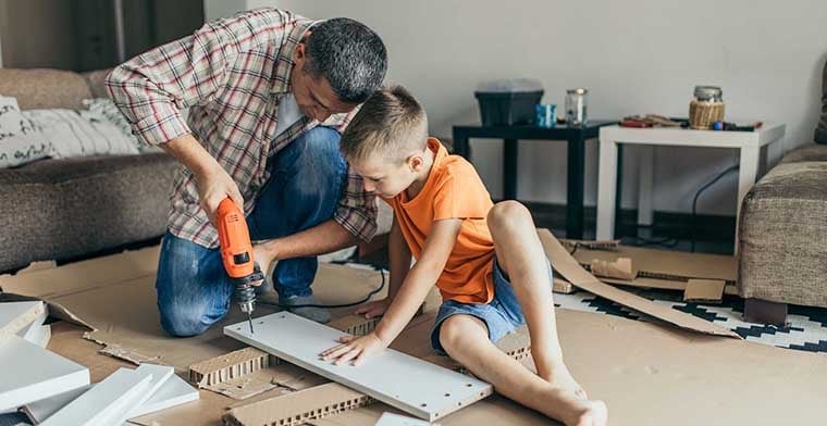 Single father is assembling furniture with his kids