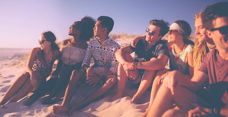 Group of friends sitting on the beach 