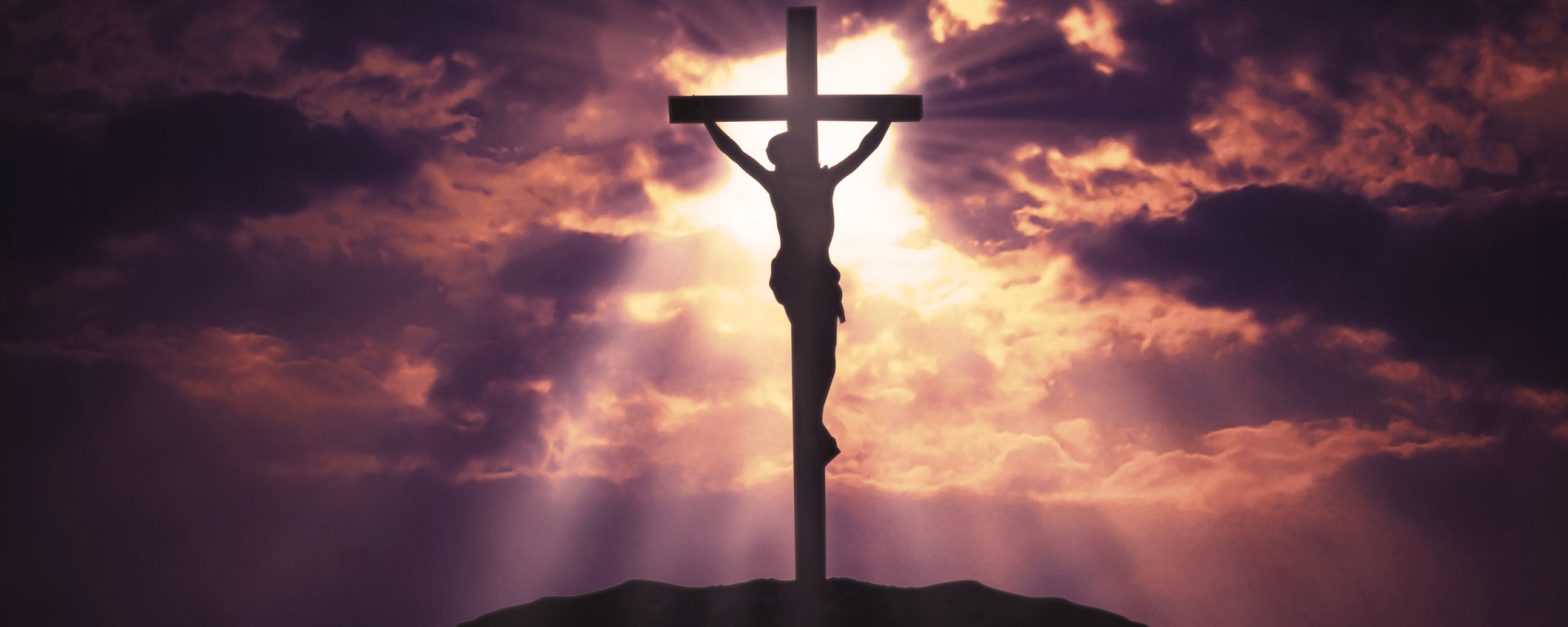 Christian cross on hill at sunrise