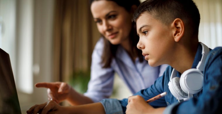 Mother helping teenager with homework
