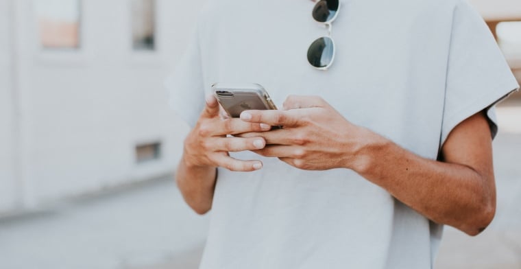 Young man looking at phone hannah-busing-