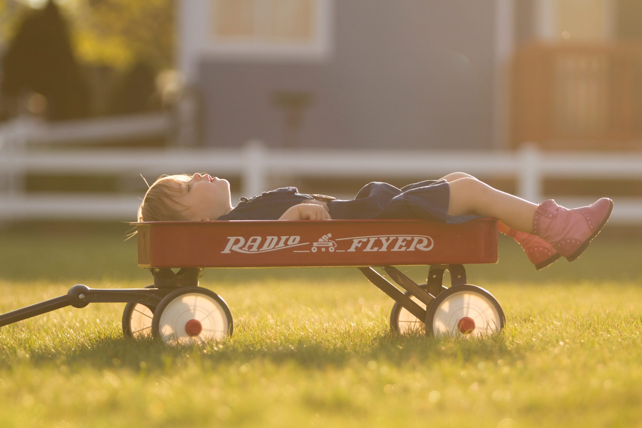 Child laying in toy trailer