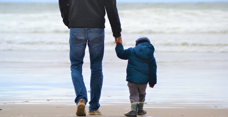 Dad and son on beach by szilvia-basso-