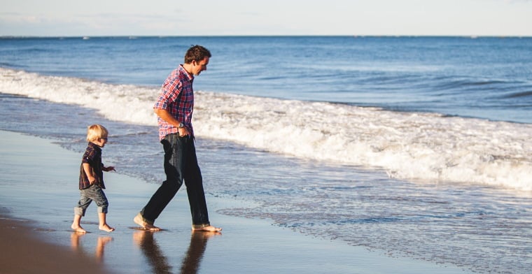Dad and son walking on beach