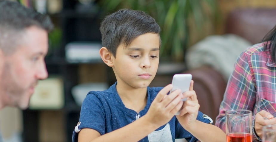 Boy with phone at dinner
