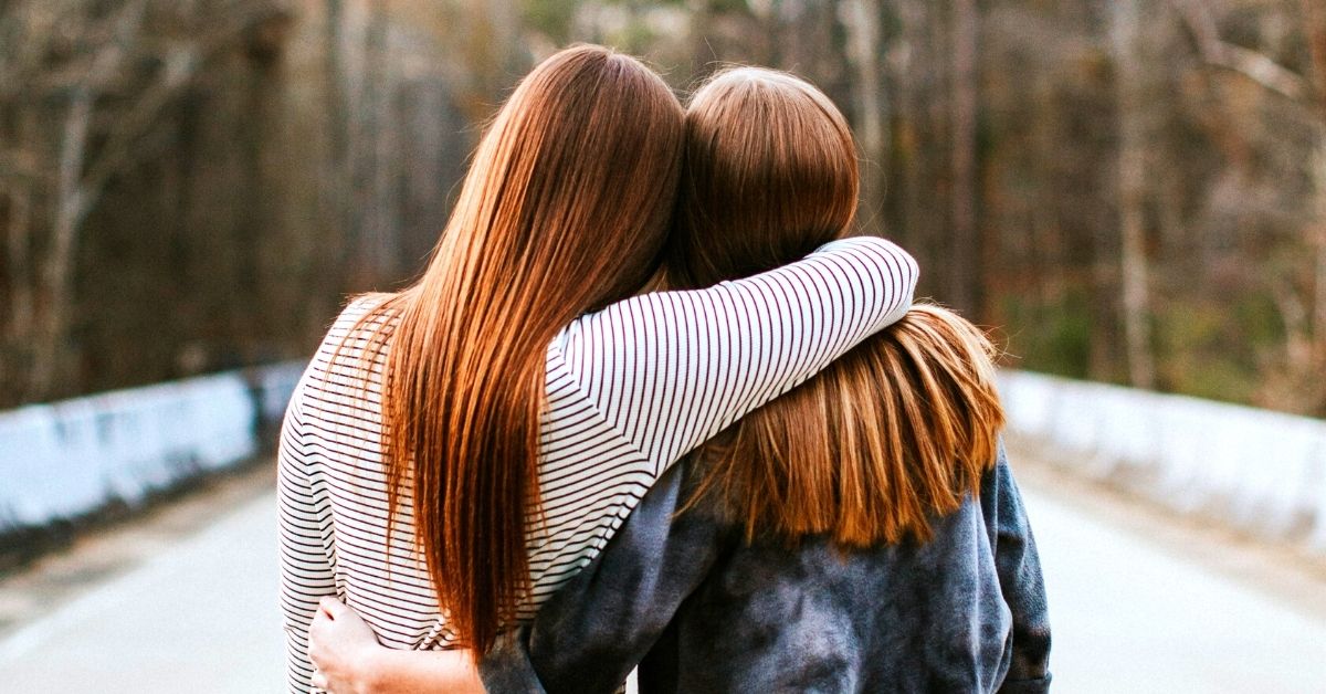 Two friends with arms around each other