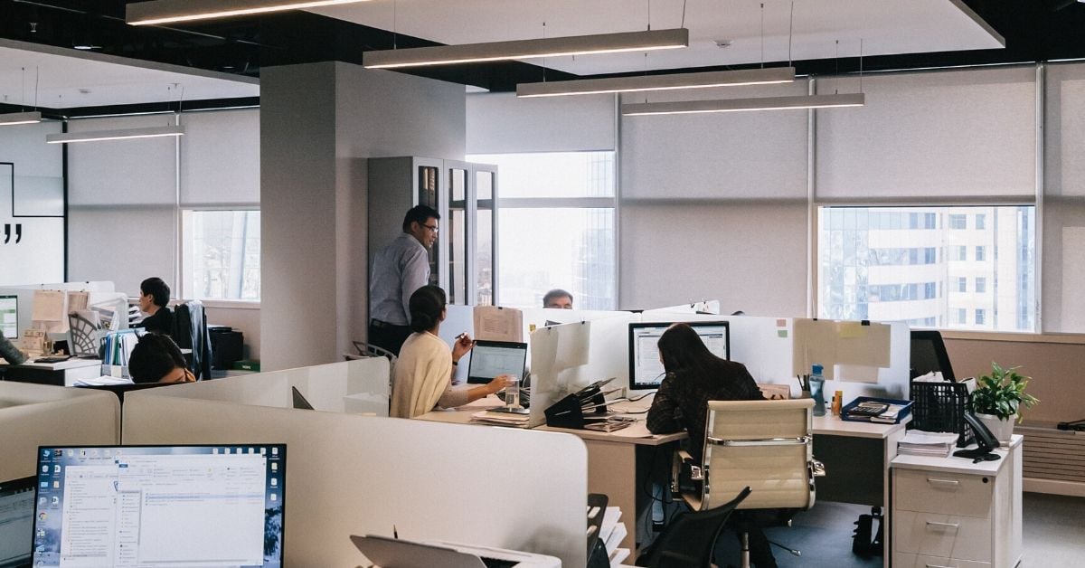 photo shows desks and people inside an office building