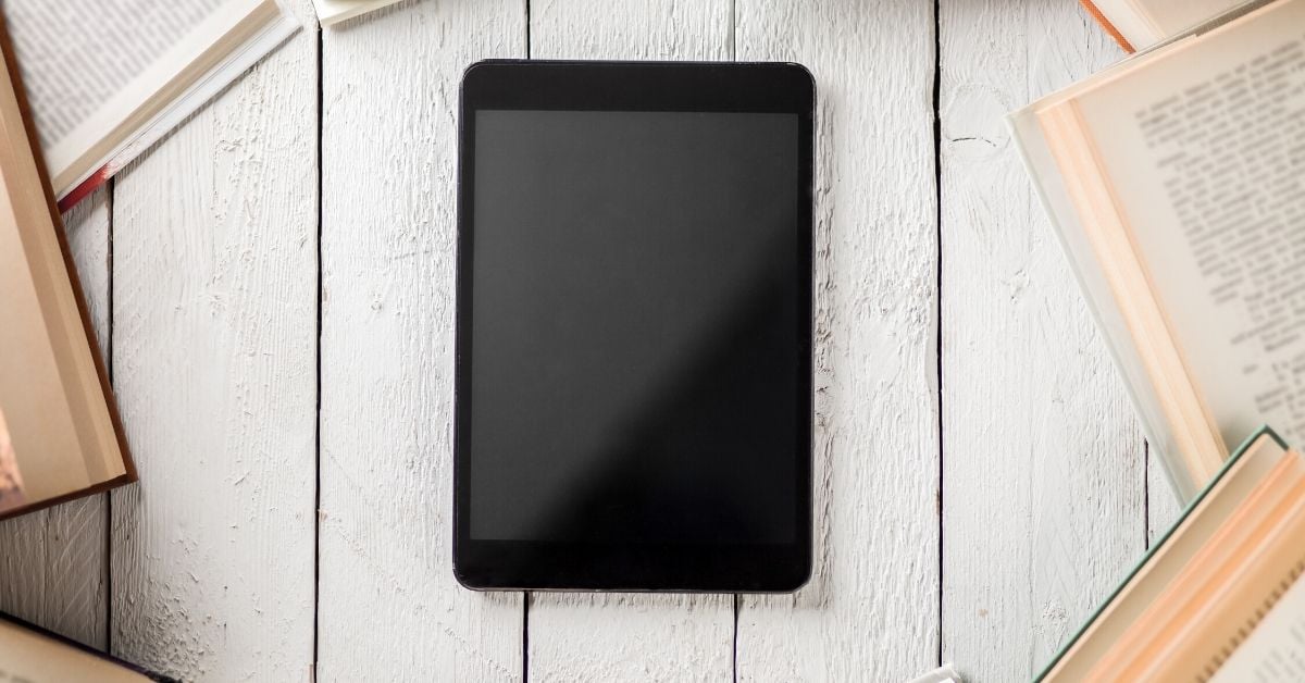 photo of a tablet surrounded by books, maybe the new format of books after COVID-19