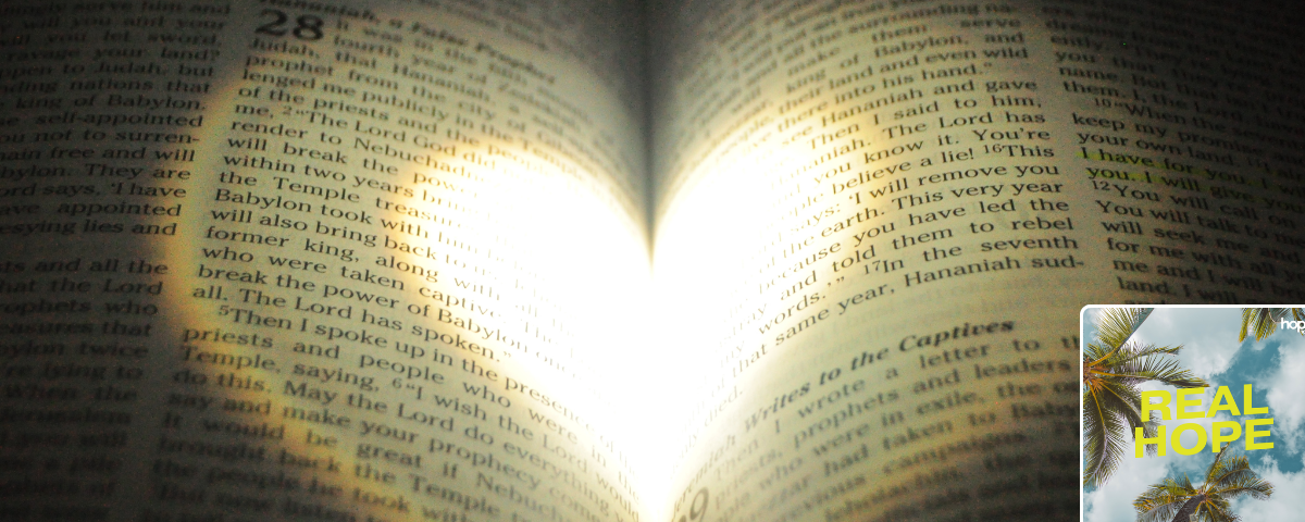 Bible open with pages made into love heart Real Hope logo